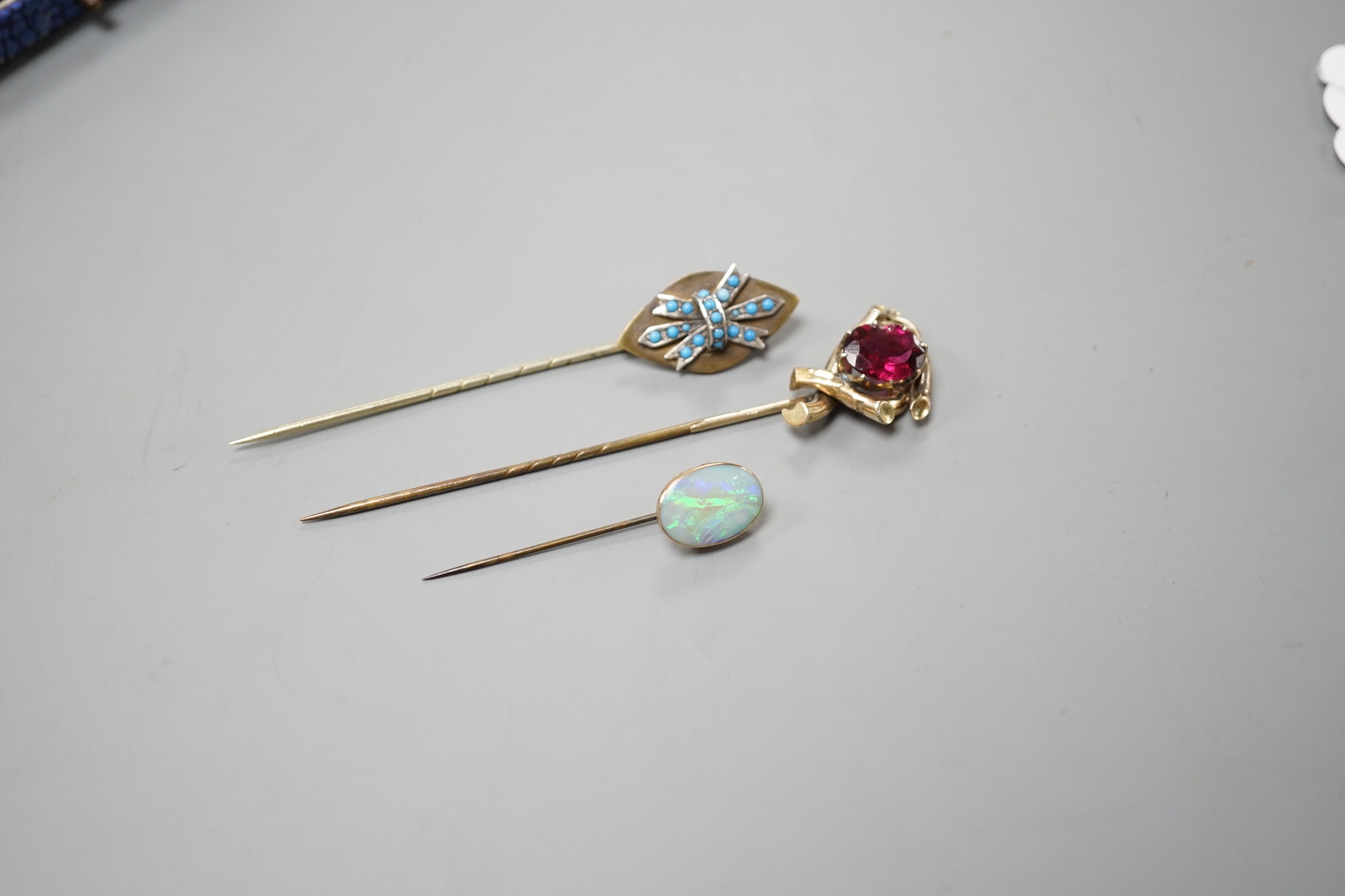 Three various base metal stick pins, one set with white opal doublet?, 45mm.